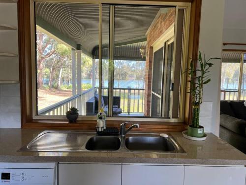 eine Küche mit einem Waschbecken und einem großen Fenster in der Unterkunft Waterfront Paradise Summer Hideaway FREE BOAT FIshing Lover in Dora Creek
