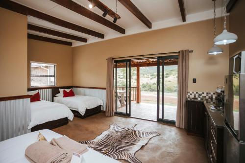 a room with two beds and a sliding glass door at Rockdell Lodge in Stutterheim