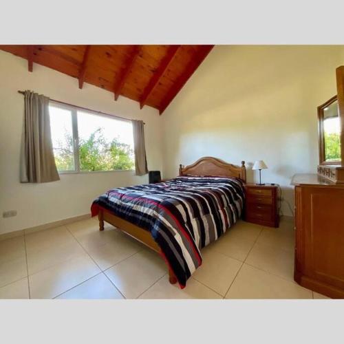 een slaapkamer met een bed en een raam bij Casa Nehuen in Lago Puelo