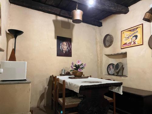 un comedor con una mesa y algunas fotos en la pared en La Preta Nera, en Giuliano di Roma