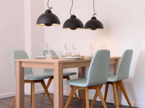 a dining room table with four chairs and a wooden table at Ohlerich Speicher App_ 37 in Wismar