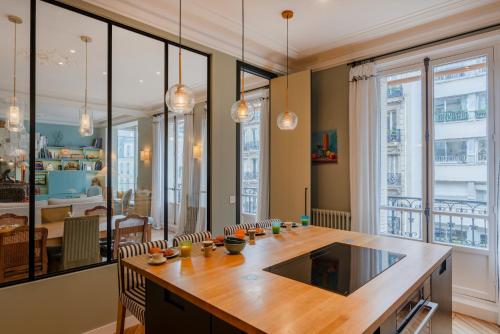 une cuisine avec une grande table en bois et des chaises dans l'établissement Paris Wagram Design Residence, à Paris