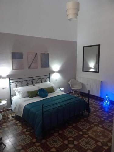 a bedroom with a large bed with a blue blanket at AREMU in Lecce