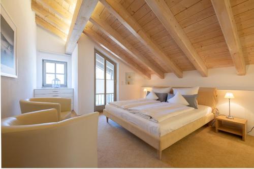 - une grande chambre avec un lit et une chaise dans l'établissement Partnachauen, à Garmisch-Partenkirchen