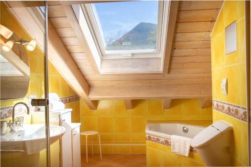 La salle de bains est pourvue d'une fenêtre, d'un lavabo et d'une baignoire. dans l'établissement Partnachauen, à Garmisch-Partenkirchen