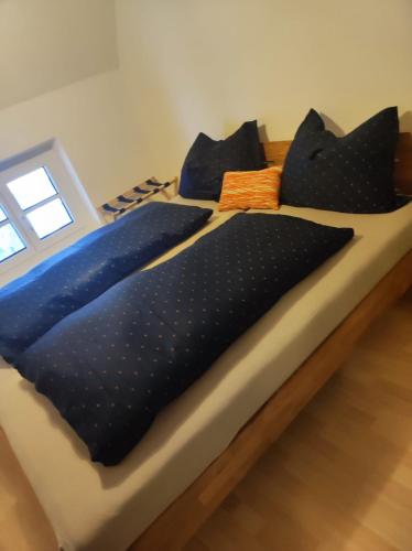 a bed with black pillows on top of it at ZENTRALE LAGE - Top 5 in Bad Ischl