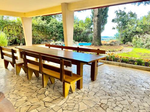 una mesa de madera y bancos en un patio en Villa degli Ulivi Terrace, en Massa Marittima