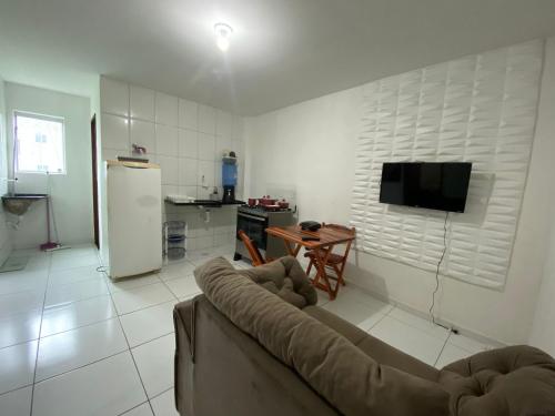 a living room with a couch and a kitchen at Temporada CG - Campina Apart-Hotel in Campina Grande