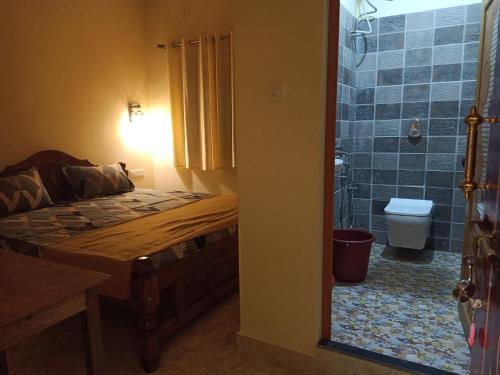um quarto com uma cama e uma casa de banho com um WC em SAI HOMESTAY em Agonda