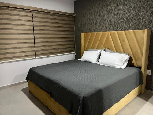 Schlafzimmer mit einem Bett mit einem Kopfteil aus Holz in der Unterkunft Bluu Habitat Lagoons in Mazatlán