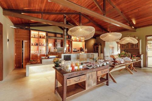 uma grande cozinha com uma mesa longa num quarto em Hotel Ponta do Madeiro em Pipa