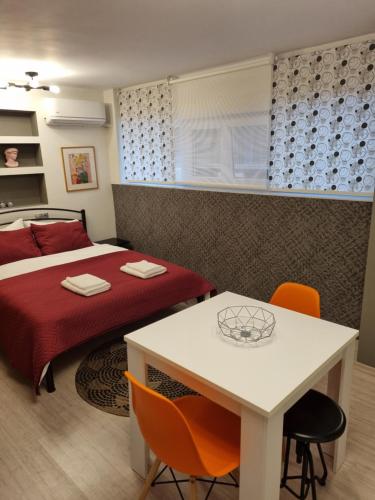 Schlafzimmer mit einem Bett, einem Tisch und Stühlen in der Unterkunft Venizelou Comfort & Living I in Kavala