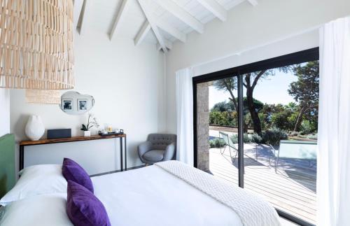 a bedroom with a bed and a sliding glass door at The Beach House in Olmeto