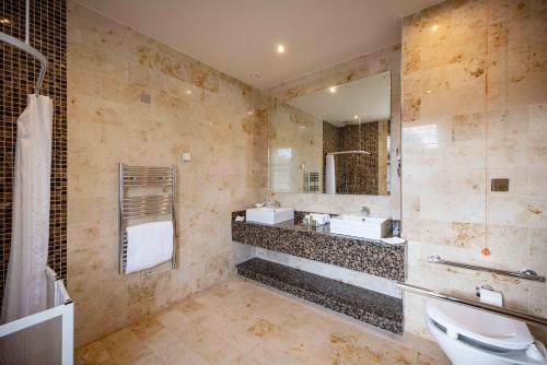 a bathroom with two sinks and a large mirror at Lough Eske Castle in Donegal