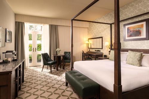 a hotel room with a large bed and a desk at Lough Eske Castle in Donegal