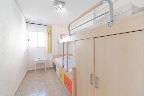 um quarto com um beliche e uma escada em Global Properties, Las dachas 1 - Apartamento en primera línea de playa em Canet d'En Berenguer