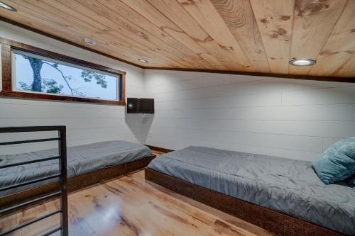 two beds in a small room with a window at Cozy Treehouse w Hot Tub, Fire Pit, Pet Friendly, Lake Access in Morganton