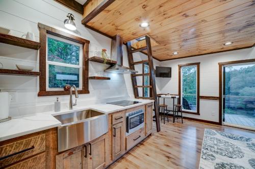 a kitchen in a tiny house with wooden ceilings and windows at Cozy Treehouse w Hot Tub, Fire Pit, Pet Friendly, Lake Access in Morganton