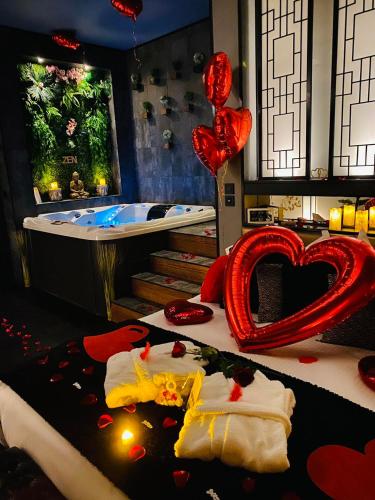 a room with a tub and a heart shaped bed at Loveroom intimiste et haut de gamme à 30 min de Toulouse in Lagrâce-Dieu