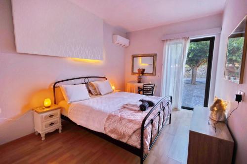 a bedroom with a bed and a large window at Villa Thalassa Stavromenos beach in Magnisía