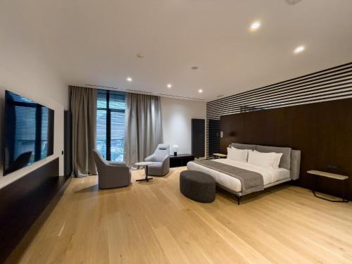 una camera con un letto e due sedie e una televisione di Emily Resort a Lviv
