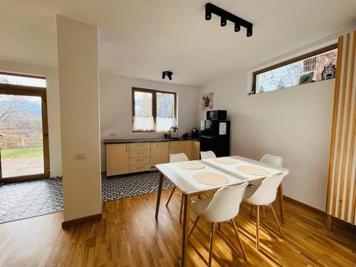una cucina e una sala da pranzo con tavolo e sedie di Casa Aluna Duo a Sohodol