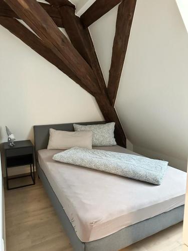 un letto in una camera con travi in legno di Ochsen-Durlach a Karlsruhe