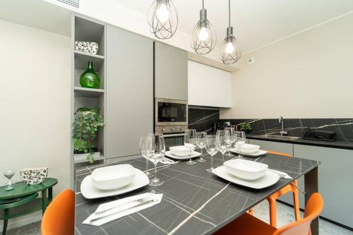 a kitchen with a dining table with chairs and wine glasses at Apt 2 min from the Cathedral with private parking in Como