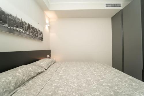 a bed in a room with a picture on the wall at Apt 2 min from the Cathedral with private parking in Como