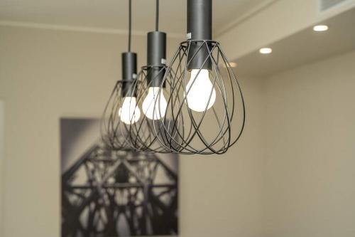a group of lights hanging from a ceiling at Apt 2 min from the Cathedral with private parking in Como