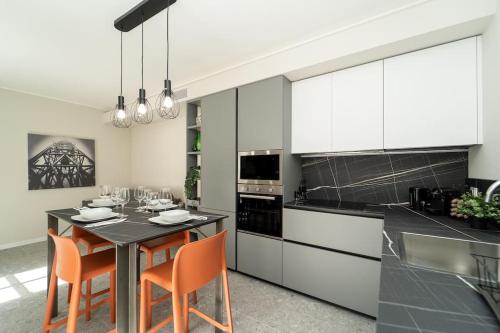 a kitchen with a table with orange chairs in it at Apt 2 min from the Cathedral with private parking in Como