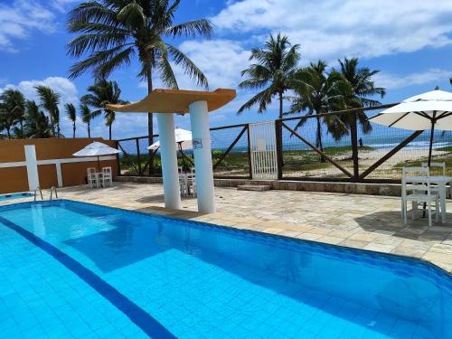 a swimming pool with a view of the ocean at APARTAMENTO 104- BGMC in Guaibim