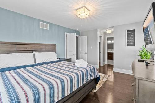 a bedroom with a bed with a striped comforter at Ski getaway - 10 min to Snow Valley/ BBQ/ Backyard in Barrie