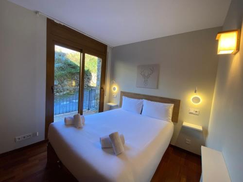 a bedroom with a large bed with two pillows on it at La Mola de Prats Canillo in Meritxell