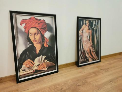 duas pinturas emolduradas de uma mulher lendo um livro em Atlas Apartment in the historical center of Košice with free private parking em Košice