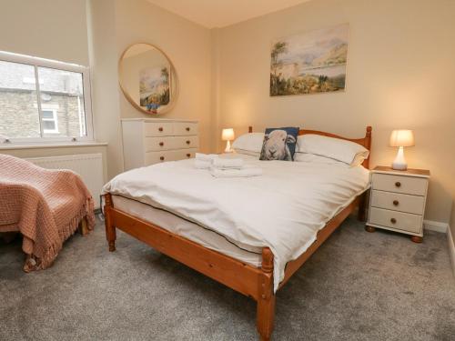 a bedroom with a large bed and a mirror at St Mary's Cottage in Windermere