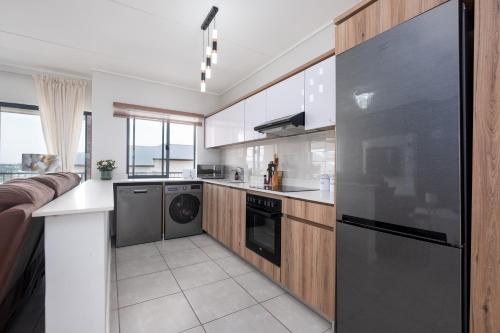 a kitchen with a refrigerator and a dishwasher at Ballito Hills Luxury Apartments in Ballito