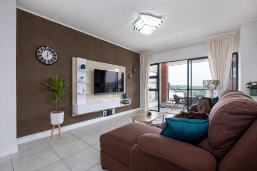 a living room with a couch and a tv at Ballito Hills Luxury Apartments in Ballito