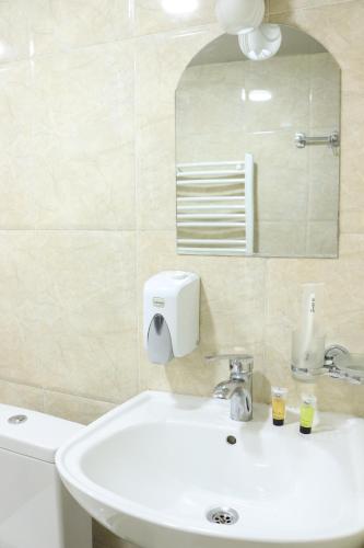 Un baño con un lavabo blanco y un espejo. en Aivani 8, en Tiflis