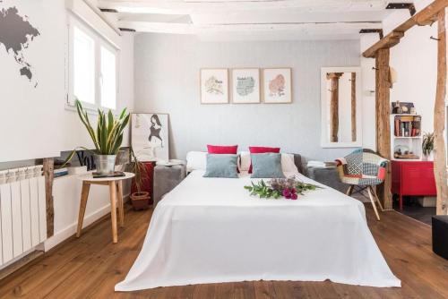 a white bedroom with a large bed and a couch at Charming La Latina Home in Madrid