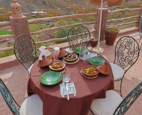 une table rouge avec des assiettes de nourriture dans l'établissement Aux lumières du toubkal Light of Toubkal, à Imlil