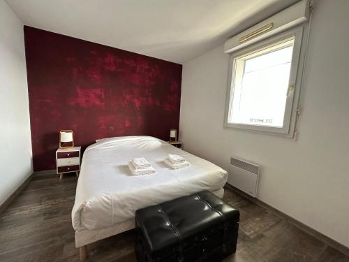 a bedroom with a white bed and a red wall at Le Balcon de Léo - Proche centre & Parc des expos in Bordeaux