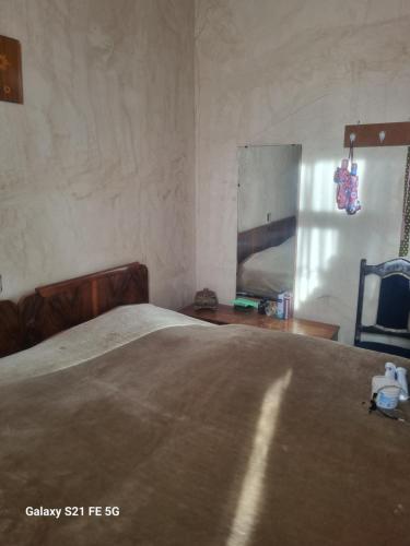 1 dormitorio con cama, silla y espejo en Happy Martkofi, en Gardabani