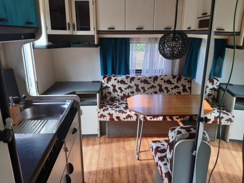 - une petite cuisine avec une table et un canapé dans une caravane dans l'établissement Petit Vessas naturestay, à Roquebrun