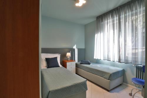 a bedroom with two beds and a window at Comosole in Como