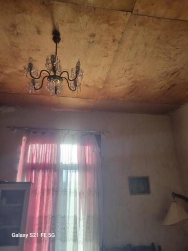 a chandelier hanging from a ceiling with a window at Happy Martkofi in Gardabani