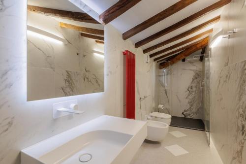 uma casa de banho com um lavatório branco e um WC. em Nello's, Villa di pregio con SPA em Cortona