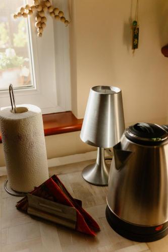 a table with a tea pot and a lamp on the floor at Apartman Zamak Sombor in Sombor