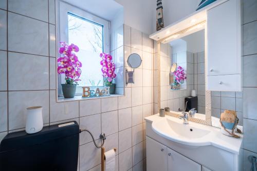 a bathroom with a sink and a toilet and a mirror at Modernes Appartement in Graz