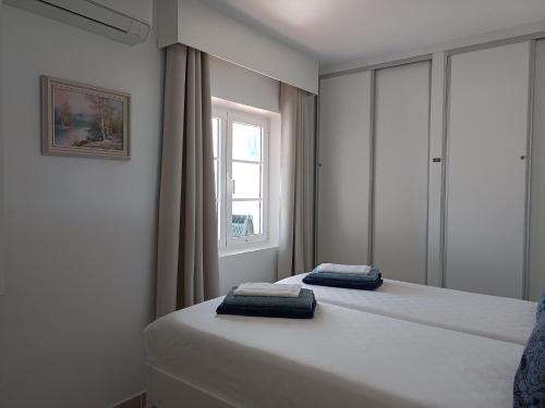a bedroom with two beds and a window at Casa Rosa in Puerto Calero